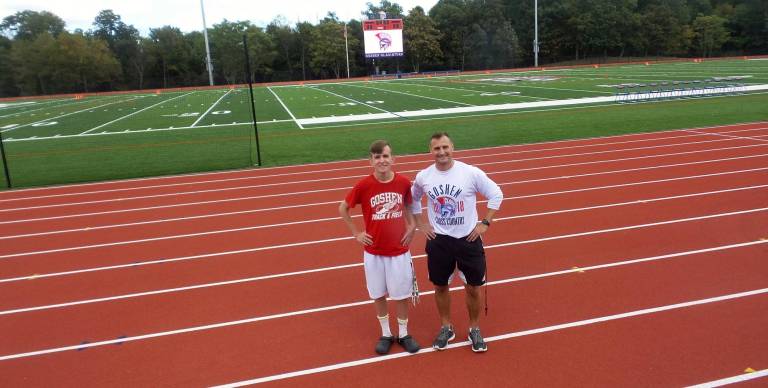Senior Max Egan (left) runs the jumbo-tron, the video board that shows close-up action. He's pictured with Coach Joe Manaseri