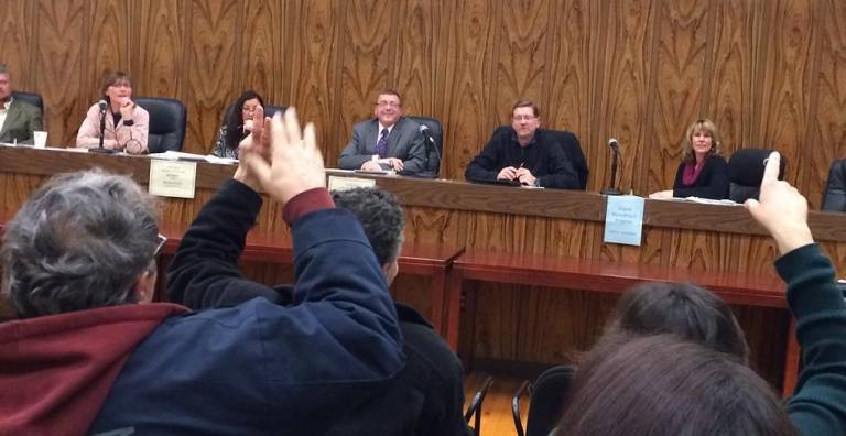 A show of hands at a recent meeting supports a town takeover of the King Tract pump station. (Photo by Edie Johnson)