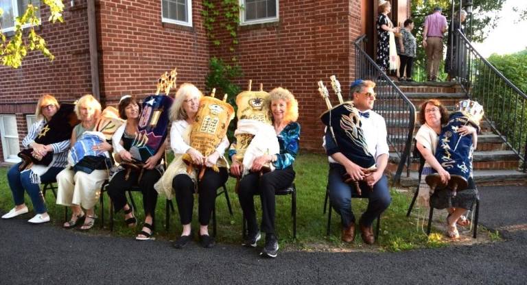 Congregants sit with the Torahs from Monroe Temple Beth-El, waiting to bring them inside the Temple Beth Shalom building.