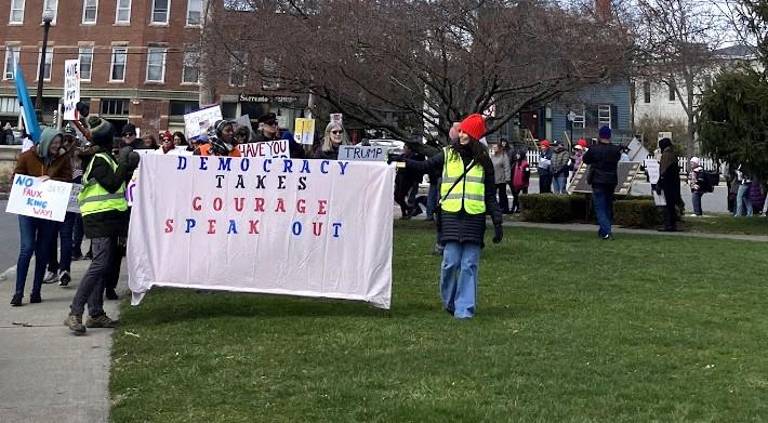 Organizers lead group with “Democracy Takes Courage” banner.