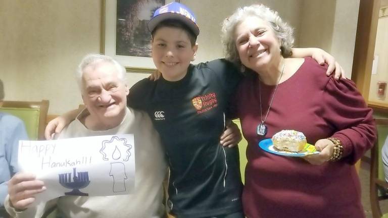 Anita Reich of Harriman and her grandson Justin of Highland Mills bring Hanukkah cheer to seniors at W Senior Living in Goshen.