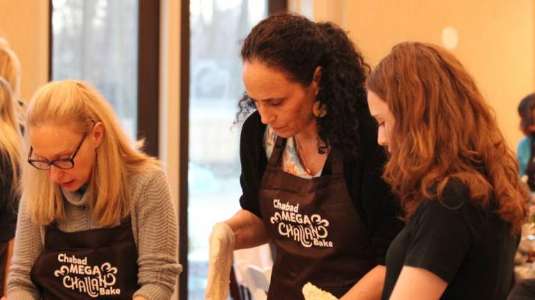 Mother and daughter Yael Block and Jordan Resty of Monroe enjoy making Challah from scratch at Chabad’s the Jewish Women’s Circle’s Mega Challah Babka Bake, joined by friend Elyssa Piker of Monroe.