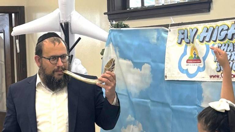 Rabbi Meir Borenstein showing the Shofar to a Chabad Sunday School student.